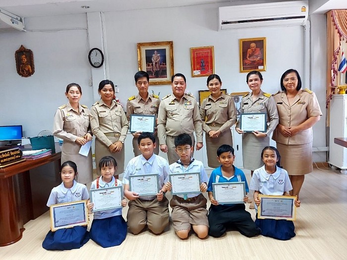 นักเรียนรับเกียรติบัตรกับผู้อำนวยการสำนักงานเขตพื้นที่การศึกษาประถมศึกษาสุพรรณบุรี เขต 1